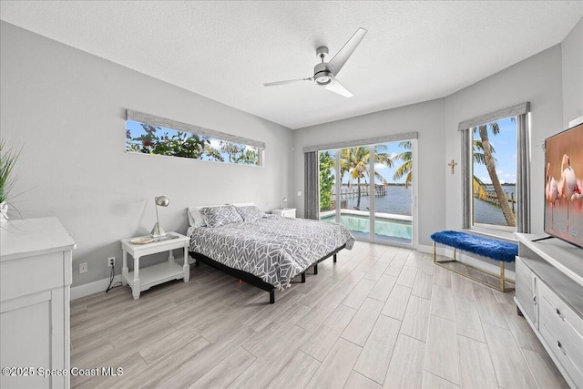 1999 S Misty Harbor Pl, Merritt Island, FL 32952 - bedroom featuring access to outside, light wood-style flooring, a textured ceiling, and a ceiling fan