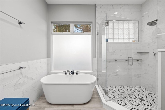 1999 S Misty Harbor Pl, Merritt Island, FL 32952 - full bath featuring a stall shower, a soaking tub, tile walls, and wainscoting