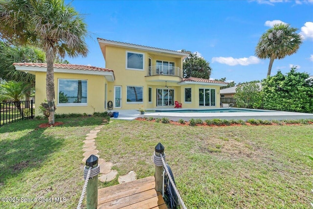 1999 S Misty Harbor Pl, Merritt Island, FL 32952 - back of house featuring a tiled roof, a fenced backyard, a balcony, stucco siding, and a patio area