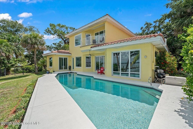 1999 S Misty Harbor Pl, Merritt Island, FL 32952 - back of property featuring a tile roof, stucco siding, an outdoor pool, and a patio area