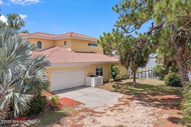 1999 S Misty Harbor Pl, Merritt Island, FL 32952 - mediterranean / spanish-style house with a tile roof, stucco siding, concrete driveway, and an attached garage