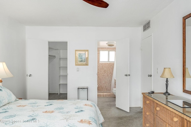 1700 Atlantic St Unit 1, Melbourne Beach, FL 32951 - carpeted bedroom featuring a spacious closet, connected bathroom, a closet, and a ceiling fan