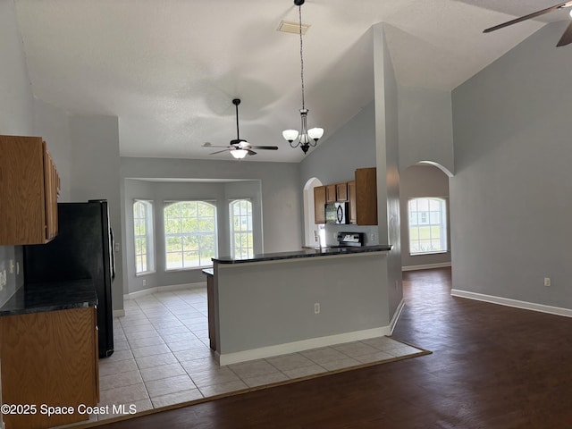 3197 Weyburn Ave SE, Palm Bay, FL 32909 - kitchen with a ceiling fan, arched walkways, black appliances, dark countertops, and high vaulted ceiling