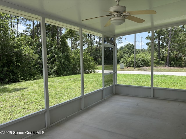 3197 Weyburn Ave SE, Palm Bay, FL 32909 - unfurnished sunroom featuring a ceiling fan, view of scattered trees, and plenty of natural light