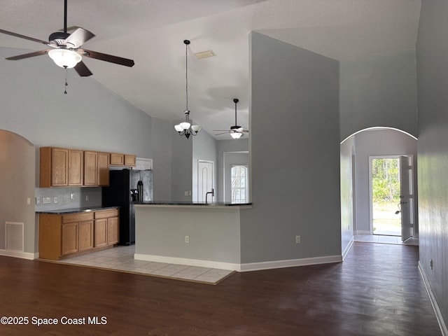 3197 Weyburn Ave SE, Palm Bay, FL 32909 - kitchen featuring high vaulted ceiling, a ceiling fan, arched walkways, black fridge, and dark countertops