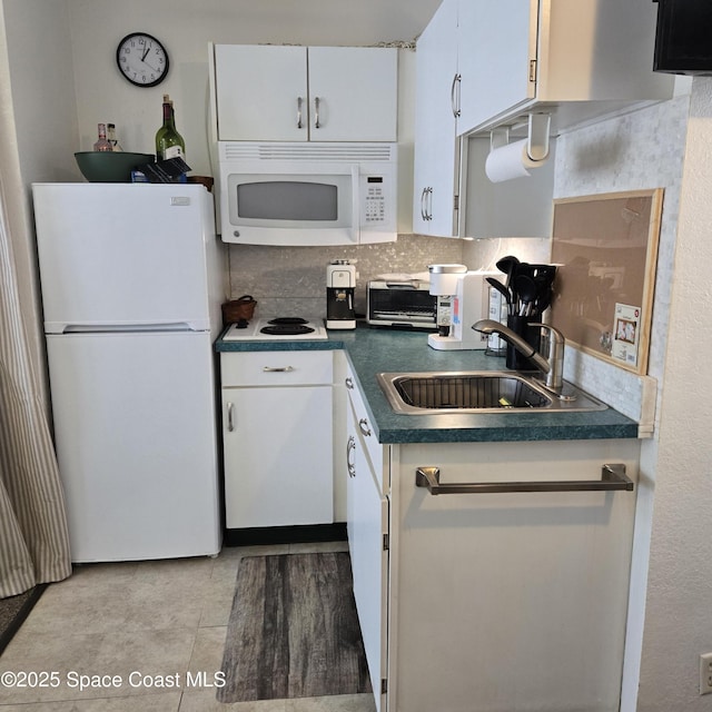 935 S Atlantic Ave Unit 234, Daytona Beach, FL 32118 - kitchen featuring white appliances, a sink, dark countertops, and white cabinetry