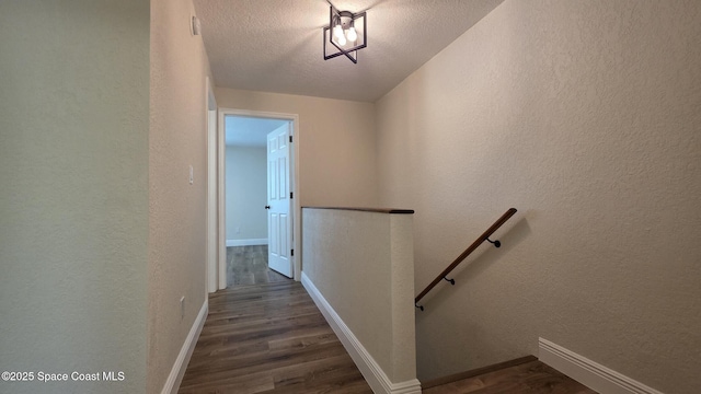 1880 Murrell Rd Unit E19, Rockledge, FL 32955 - hallway with an upstairs landing, wood finished floors, a textured wall, a textured ceiling, and baseboards
