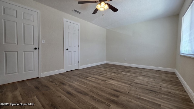 1880 Murrell Rd Unit E19, Rockledge, FL 32955 - unfurnished bedroom featuring dark wood finished floors, lofted ceiling, a ceiling fan, a textured ceiling, and baseboards