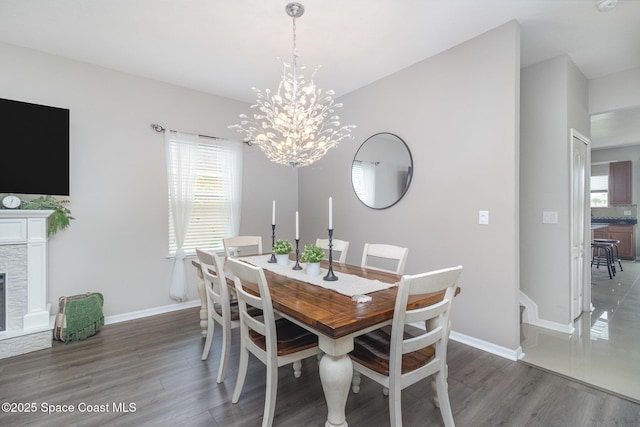 2039 Snapdragon Dr NW, Palm Bay, FL 32907 - dining area with wood finished floors, a chandelier, baseboards, and a fireplace