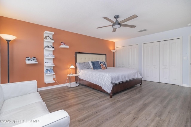 2039 Snapdragon Dr NW, Palm Bay, FL 32907 - bedroom with two closets, wood finished floors, and baseboards