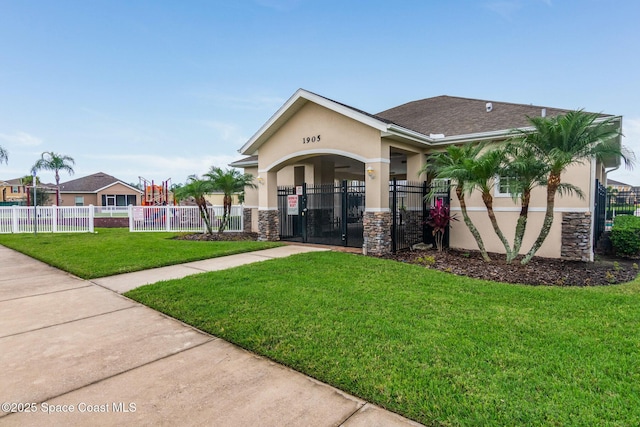 2039 Snapdragon Dr NW, Palm Bay, FL 32907 - view of front facade with stucco siding, stone siding, a gate, and roof with shingles
