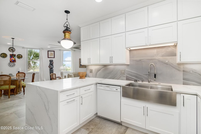 333 N Atlantic Ave Unit 333, Cocoa Beach, FL 32931 - kitchen featuring white dishwasher, a sink, a peninsula, backsplash, and white cabinetry