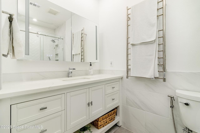 333 N Atlantic Ave Unit 333, Cocoa Beach, FL 32931 - bathroom with radiator heating unit, vanity, toilet, a shower, and a towel warming rack