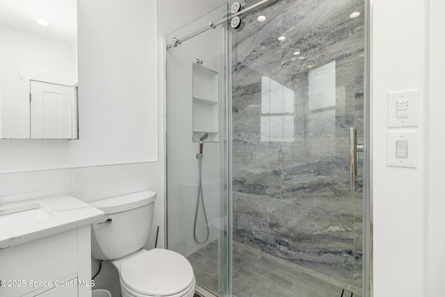 333 N Atlantic Ave Unit 333, Cocoa Beach, FL 32931 - bathroom featuring vanity, a shower stall, toilet, and tile walls