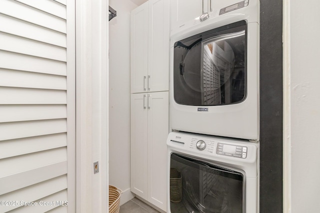 333 N Atlantic Ave Unit 333, Cocoa Beach, FL 32931 - laundry area featuring stacked washer / drying machine, cabinet space, and tile patterned floors