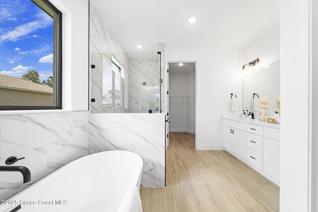 337 Fifer St SE, Palm Bay, FL 32909 - bathroom featuring a soaking tub, a marble finish shower, a walk in closet, vanity, and recessed lighting