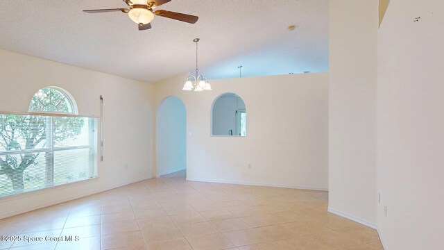 2178 Redwood Cir NE, Palm Bay, FL 32905 - empty room with ceiling fan, arched walkways, lofted ceiling, light tile patterned flooring, and a chandelier