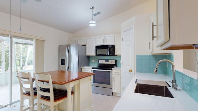 2178 Redwood Cir NE, Palm Bay, FL 32905 - kitchen featuring appliances with stainless steel finishes, a sink, backsplash, light tile patterned floors, and lofted ceiling