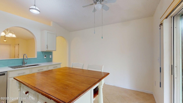 2178 Redwood Cir NE, Palm Bay, FL 32905 - kitchen with a sink, arched walkways, ceiling fan, white cabinetry, and decorative backsplash