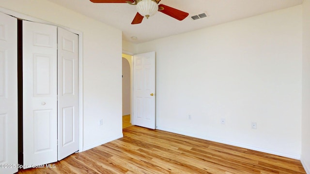 2178 Redwood Cir NE, Palm Bay, FL 32905 - unfurnished bedroom with light wood-type flooring, baseboards, arched walkways, a closet, and a ceiling fan