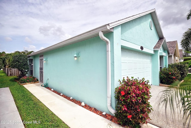 2178 Redwood Cir NE, Palm Bay, FL 32905 - view of side of home with stucco siding and a garage