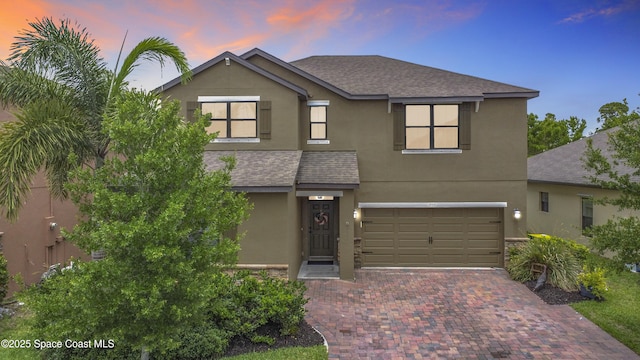 1535 Fuji Dr, Melbourne, FL 32940 - traditional-style house featuring stucco siding, an attached garage, roof with shingles, and decorative driveway