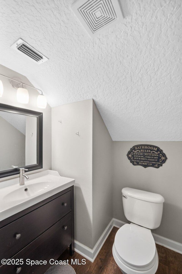 1236 Foxridge Pl, Melbourne, FL 32940 - half bathroom featuring a textured ceiling, vanity, wood finished floors, and lofted ceiling