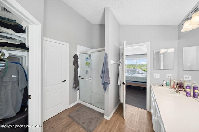 1236 Foxridge Pl, Melbourne, FL 32940 - bathroom featuring ensuite bathroom, wood finished floors, a stall shower, vanity, and a textured ceiling