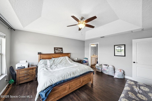 1236 Foxridge Pl, Melbourne, FL 32940 - bedroom with a raised ceiling, wood finished floors, a textured ceiling, ceiling fan, and connected bathroom