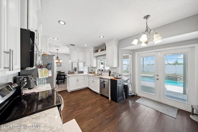 1236 Foxridge Pl, Melbourne, FL 32940 - kitchen with a chandelier, stainless steel appliances, light countertops, dark wood-style flooring, and a textured ceiling