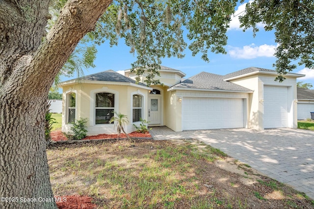 3977 Foothill Dr, Titusville, FL 32796 - view of front of property featuring an attached garage, stucco siding, and a shingled roof