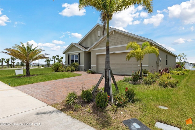 1103 Dunes Ave, Melbourne, FL 32904 - view of front facade with an attached garage, stucco siding, decorative driveway, and a front lawn