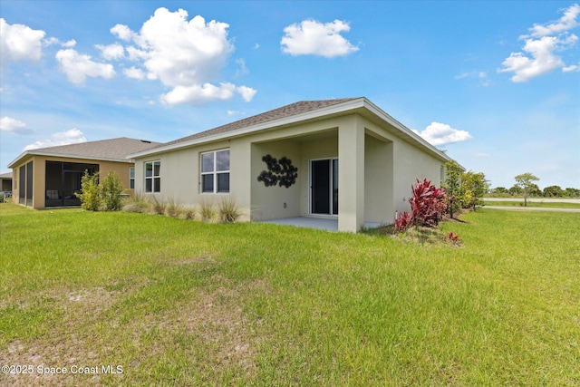 1103 Dunes Ave, Melbourne, FL 32904 - rear view of house with stucco siding and a lawn
