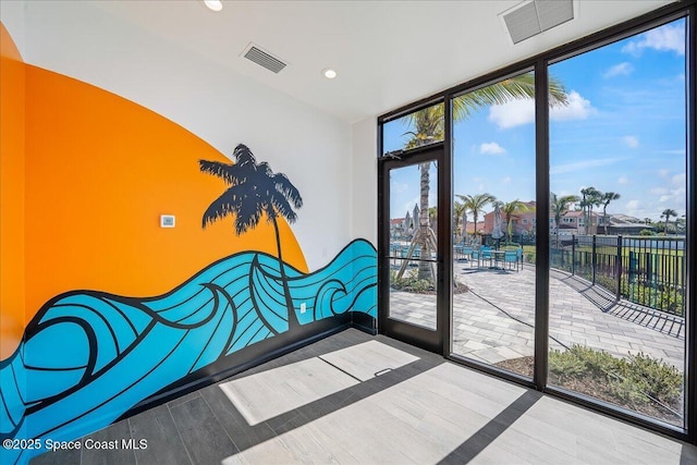 3031 Hafen Ln Unit 306, Melbourne Beach, FL 32951 - unfurnished bedroom with access to outside, expansive windows, wood finished floors, and recessed lighting