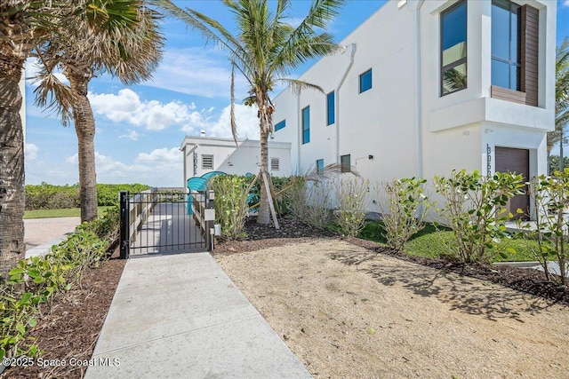 3031 Hafen Ln Unit 306, Melbourne Beach, FL 32951 - view of property exterior featuring a gate, stucco siding, and a garage