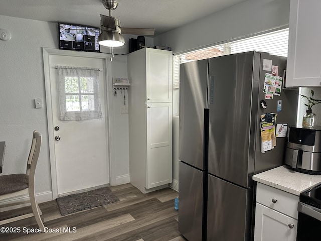 1602 Harvard Dr, Cocoa, FL 32922 - kitchen featuring freestanding refrigerator, white cabinets, wood finished floors, and light stone counters
