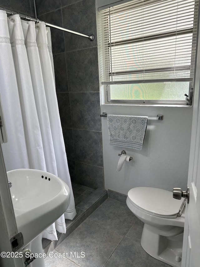 1602 Harvard Dr, Cocoa, FL 32922 - bathroom with tiled shower, toilet, plenty of natural light, and tile patterned flooring
