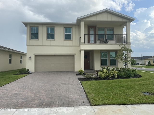 743 Veridian Cir NW, Palm Bay, FL 32907 - view of front of home with a balcony, board and batten siding, decorative driveway, a front yard, and an attached garage