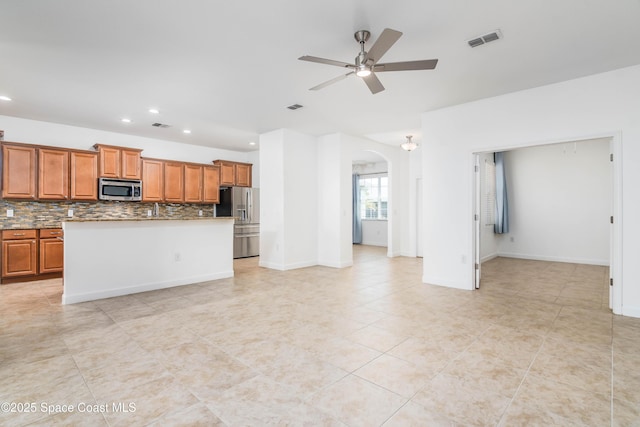 3485 Sansome Cir, Melbourne, FL 32940 - kitchen with stainless steel appliances, arched walkways, a ceiling fan, recessed lighting, and backsplash