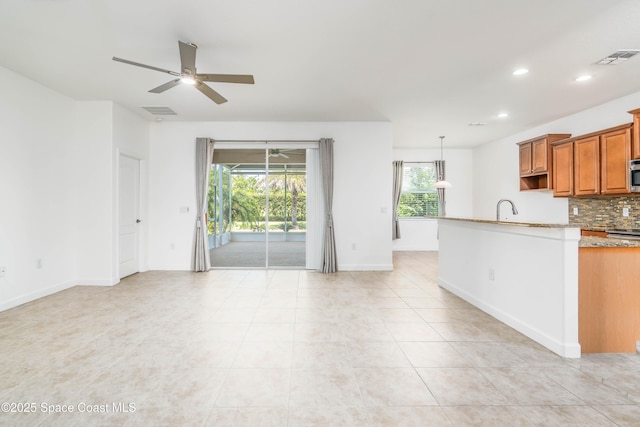 3485 Sansome Cir, Melbourne, FL 32940 - kitchen with brown cabinets, ceiling fan, decorative backsplash, recessed lighting, and light tile patterned floors