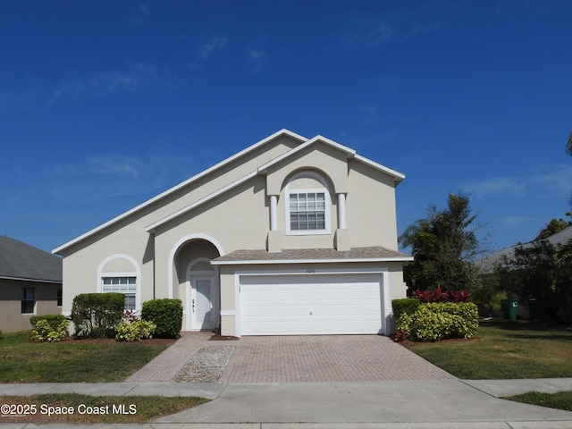 5290 Somerville Dr, Rockledge, FL 32955 - traditional home with decorative driveway, stucco siding, a garage, and a front yard
