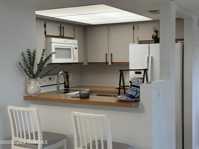 933 Sonesta Ave NE Unit 208, Palm Bay, FL 32905 - kitchen featuring white appliances and a breakfast bar area