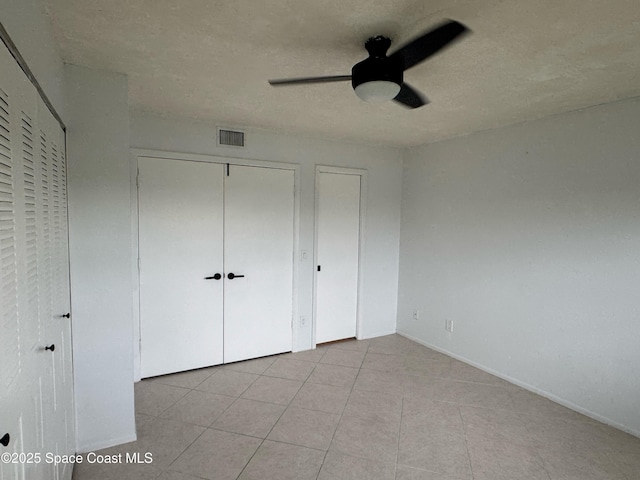 933 Sonesta Ave NE Unit 208, Palm Bay, FL 32905 - unfurnished bedroom with a ceiling fan, two closets, and light tile patterned flooring