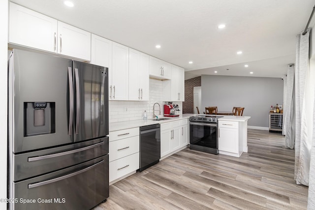 813 Laurel Dr, Rockledge, FL 32955 - kitchen featuring stainless steel appliances, a peninsula, a sink, light countertops, and white cabinetry