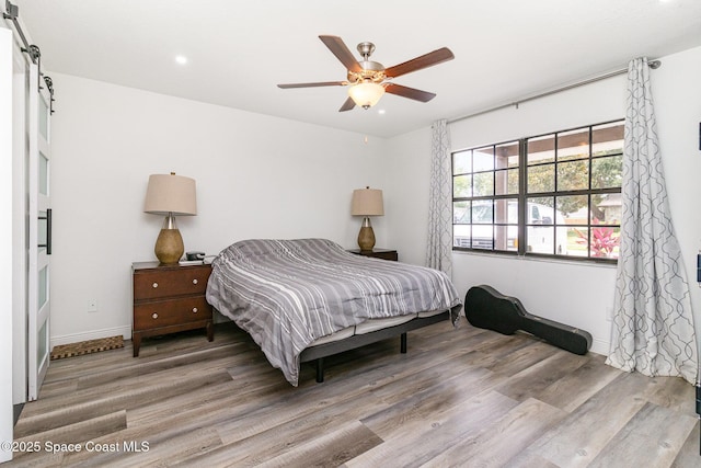 813 Laurel Dr, Rockledge, FL 32955 - bedroom with wood finished floors, baseboards, recessed lighting, a barn door, and ceiling fan