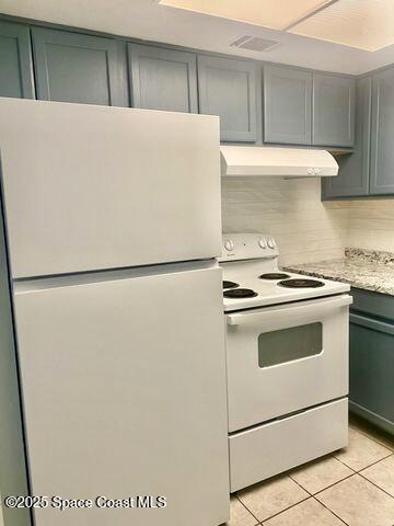2170 Knox Mcrae Dr Unit 2, Titusville, FL 32780 - kitchen with white appliances, custom exhaust hood, light tile patterned floors, and backsplash