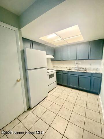 2170 Knox Mcrae Dr Unit 2, Titusville, FL 32780 - kitchen with white appliances, light tile patterned flooring, under cabinet range hood, and light countertops