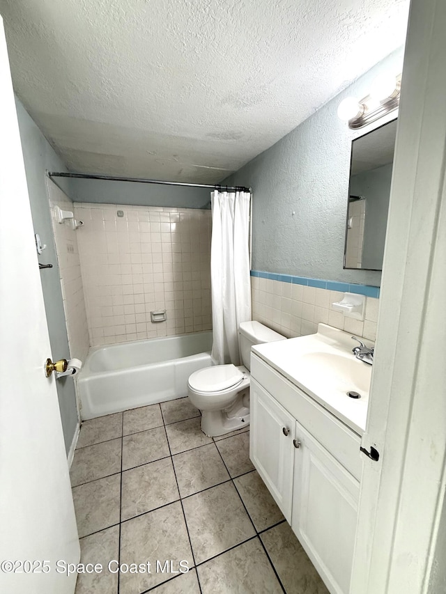 2170 Knox Mcrae Dr Unit 2, Titusville, FL 32780 - full bathroom with a textured ceiling, vanity, shower / tub combo with curtain, tile patterned floors, and tile walls