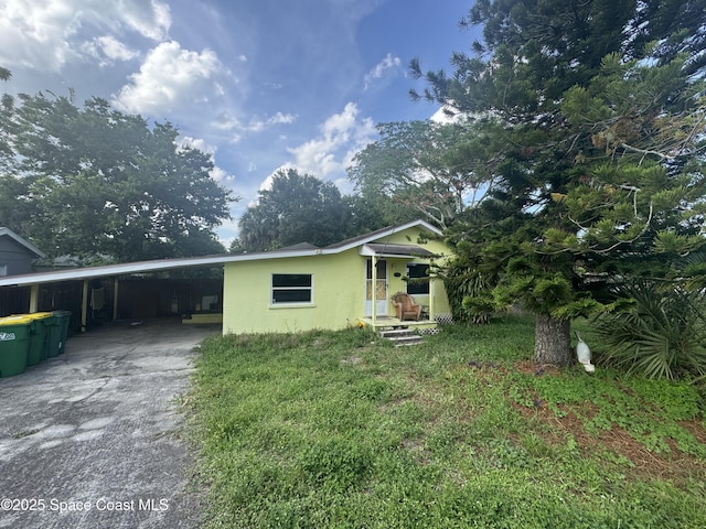 1236 Jackson St, Cocoa, FL 32922 - view of front facade with an attached carport, driveway, and stucco siding