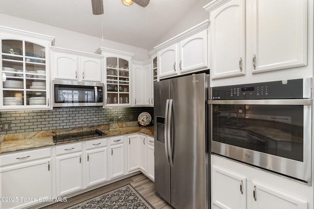 142 Ocean Garden Ln, Cape Canaveral, FL 32920 - kitchen with appliances with stainless steel finishes, white cabinets, dark wood finished floors, a ceiling fan, and backsplash